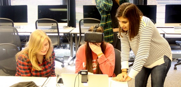 Three first-year SJMC students in the Multimedia Lab; the student in the center is wearing a virtual reality headset.