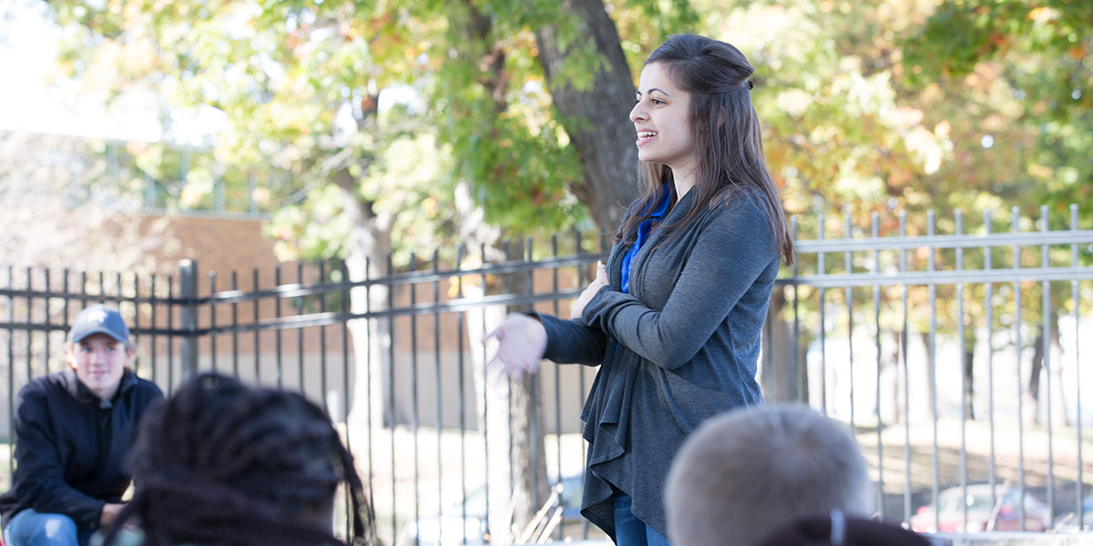 A member of Drake student council speaking to other students outside on campus
