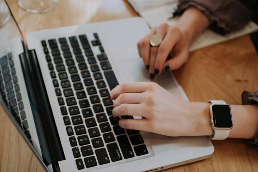 Hands typing on a laptop keyboard