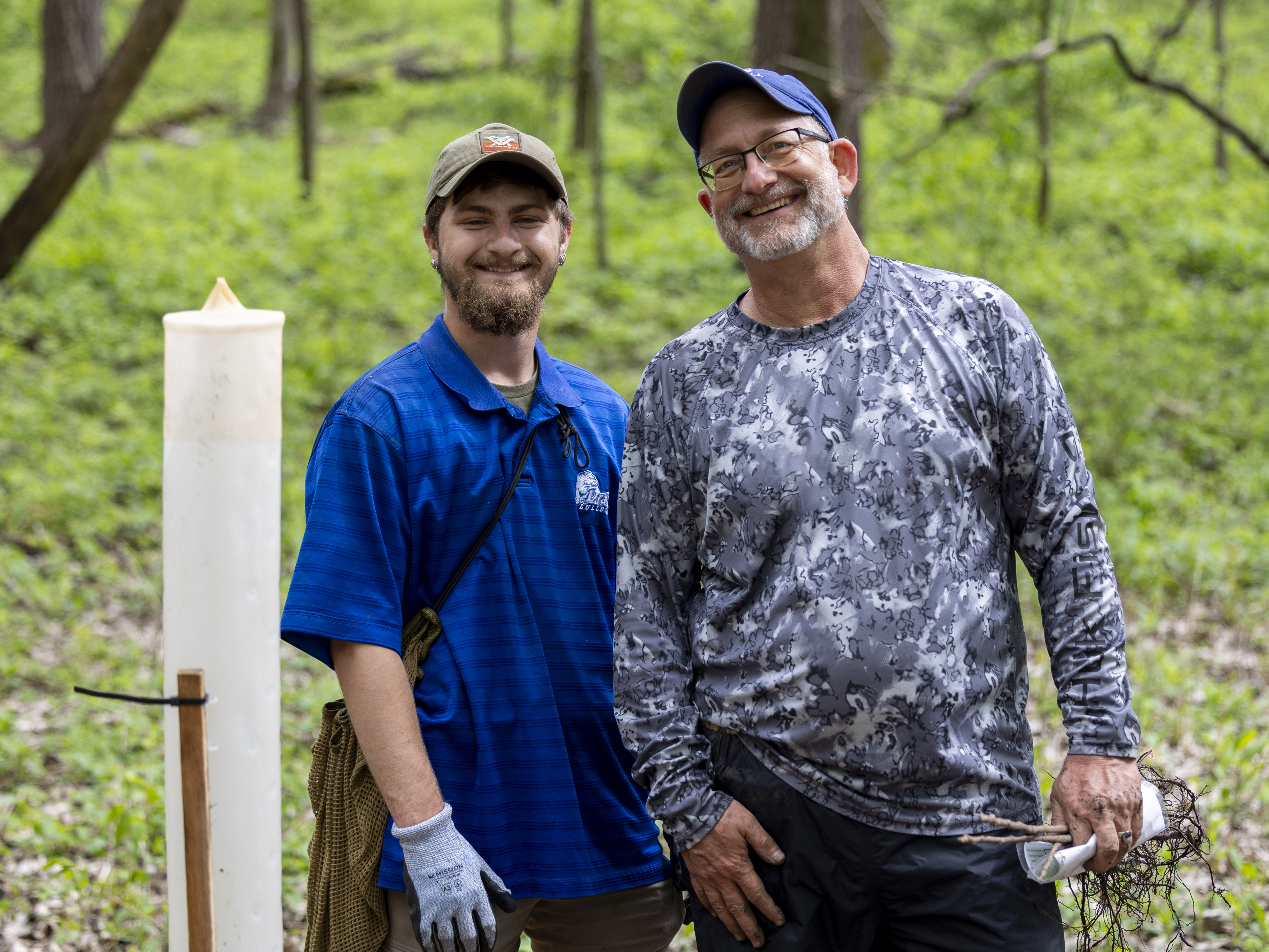 Drake faculty members and staff during an outdoor cleanup project in a wooded area