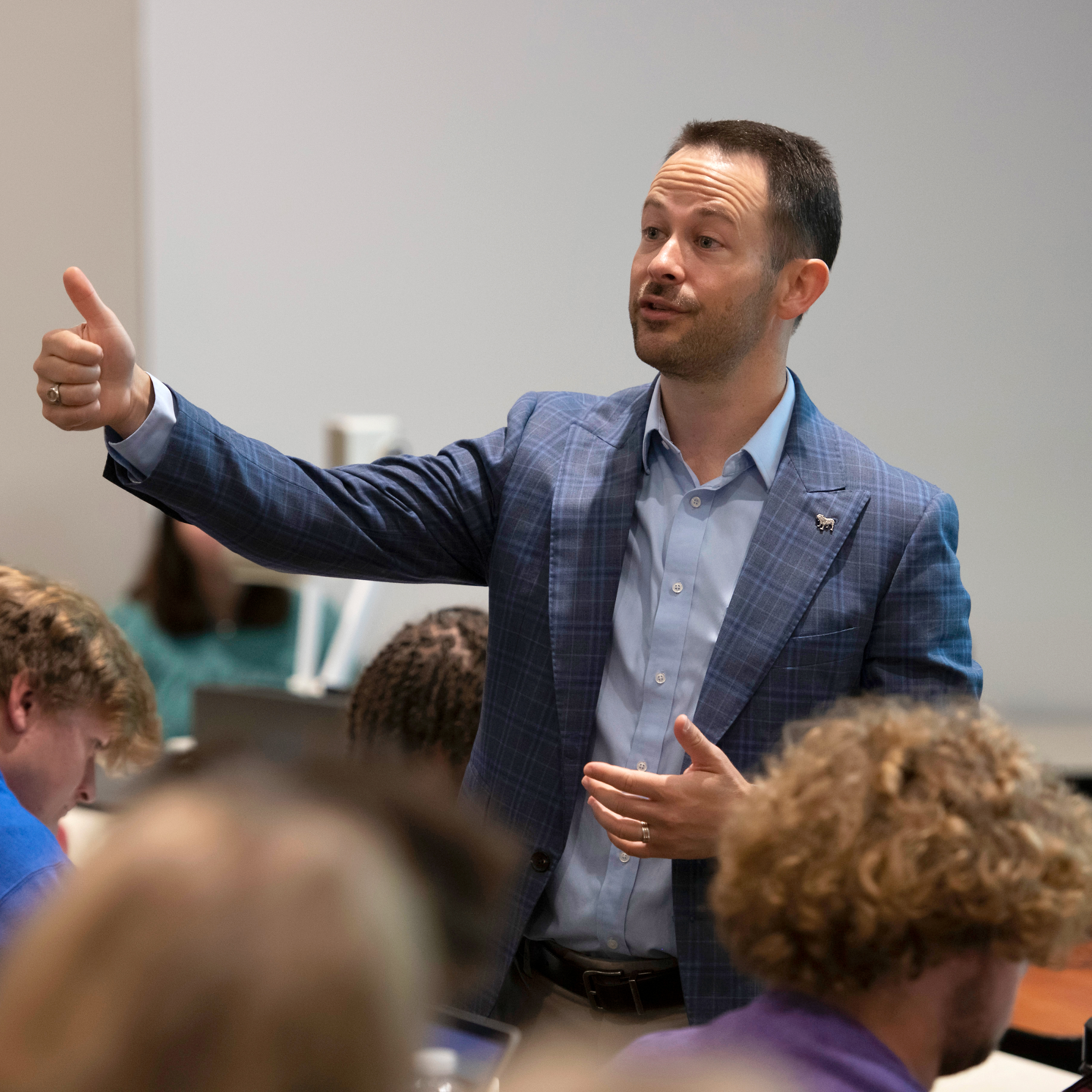 A Drake teacher gives a thumbs up to a classroom of students