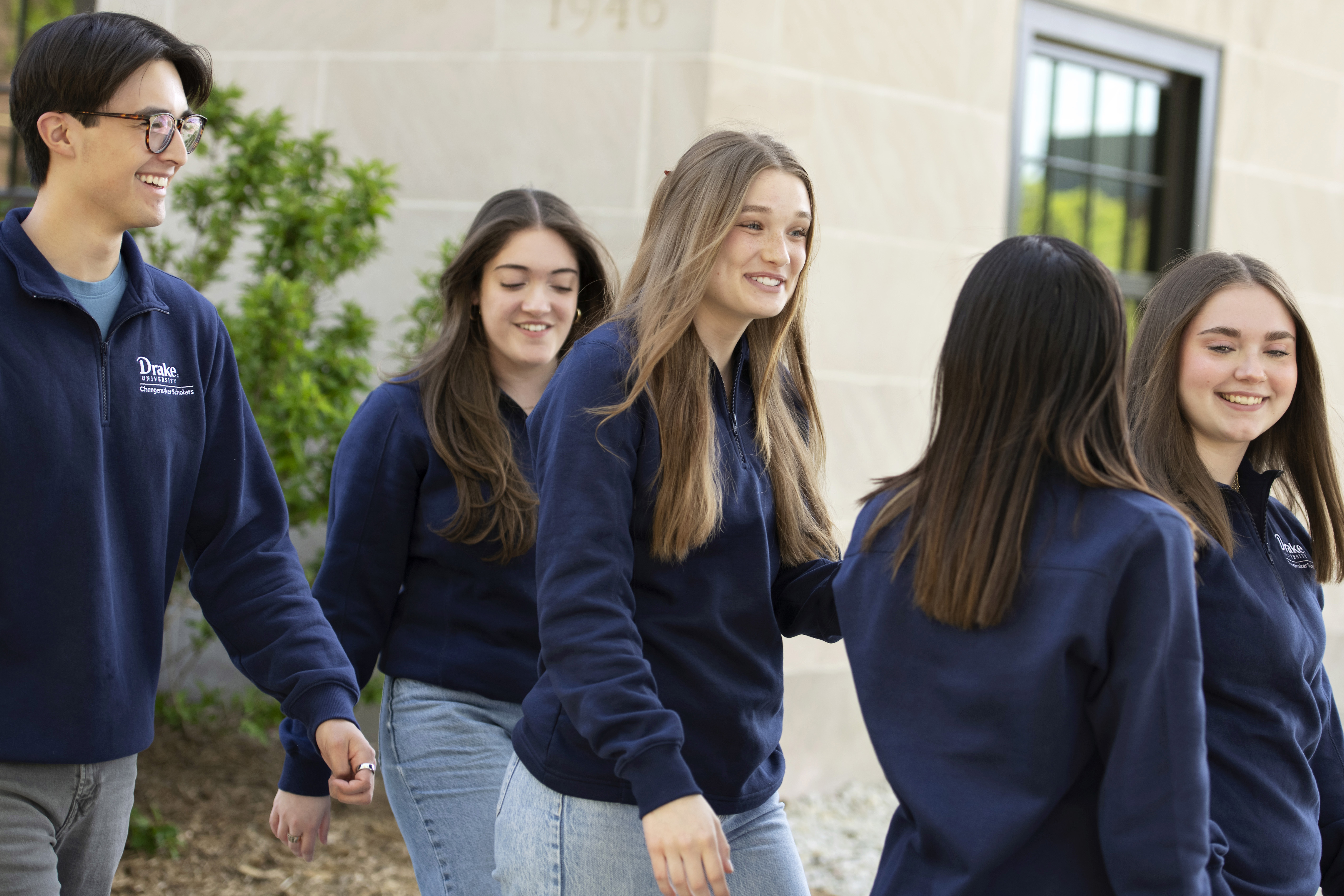 Wearing navy blue sweatshirts, students from one of Drake University's many service organizations department campus for a team project