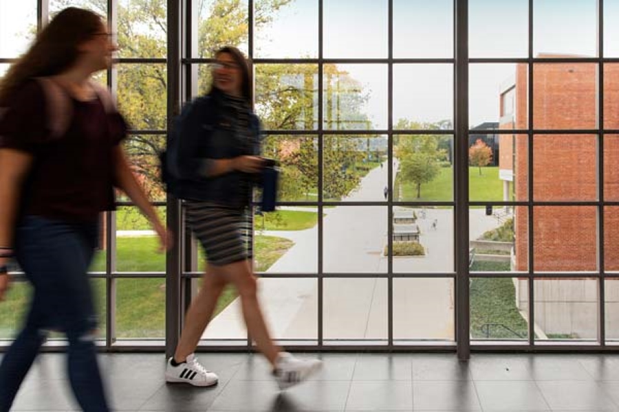 Two students walking in a campus building