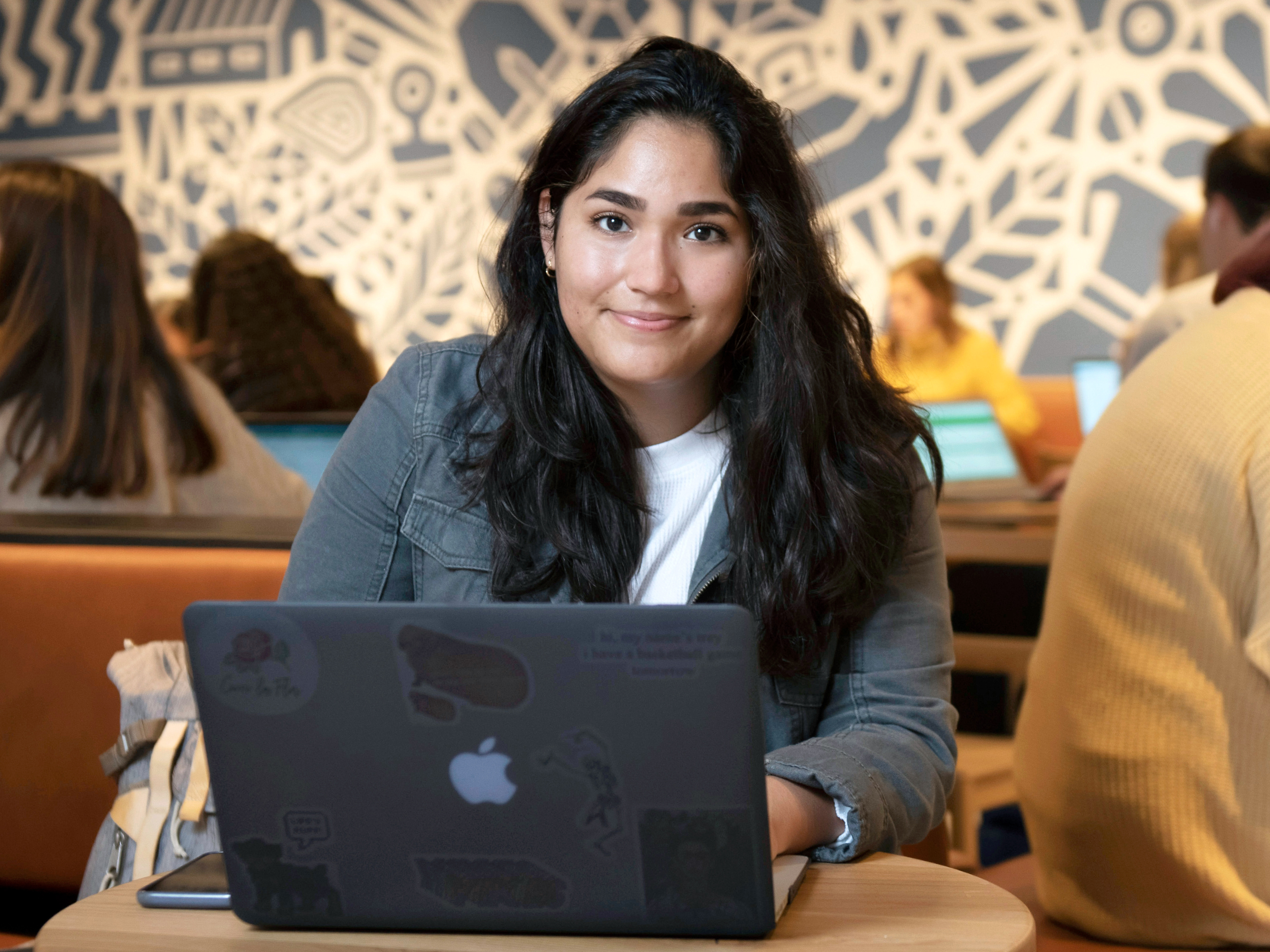 A Drake student studies in a common area on campus, laptop open