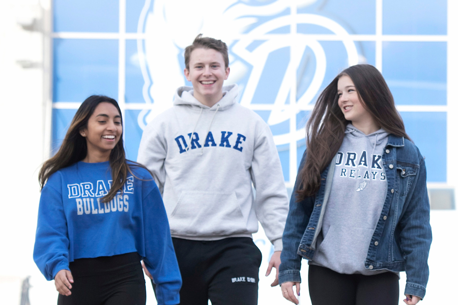 Three students in Drake attire smiling while walking on campus