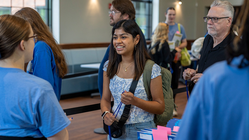 A female student talking with an orientation leader at Summer Orientation during Check-In at the Johansen Student Center.