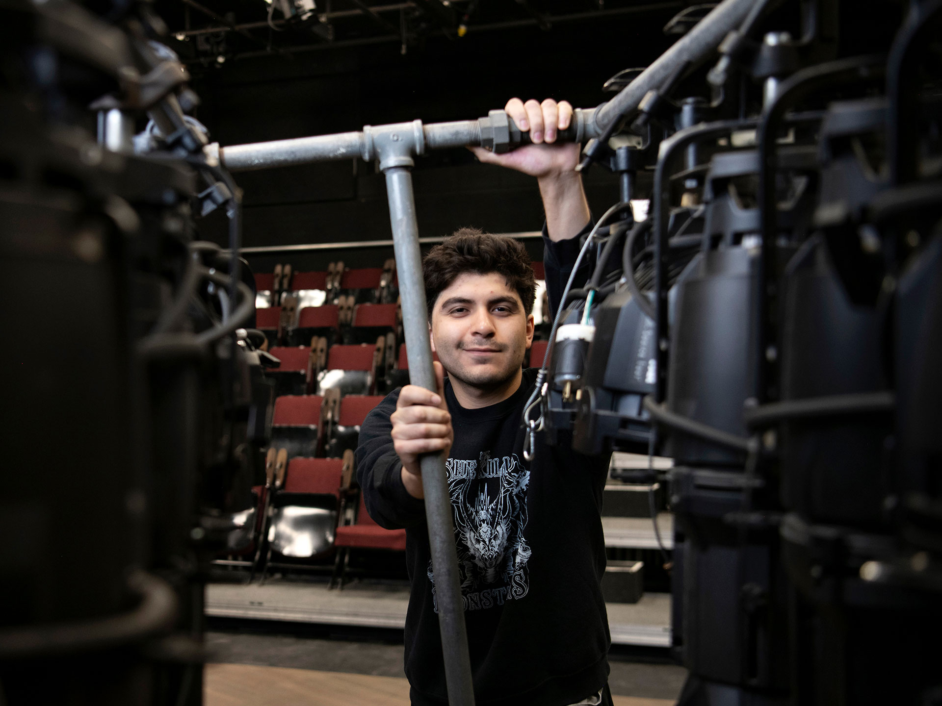 A Drake College of Arts and Sciences student gets hands-on experience with theatre lighting equipment during a campus production