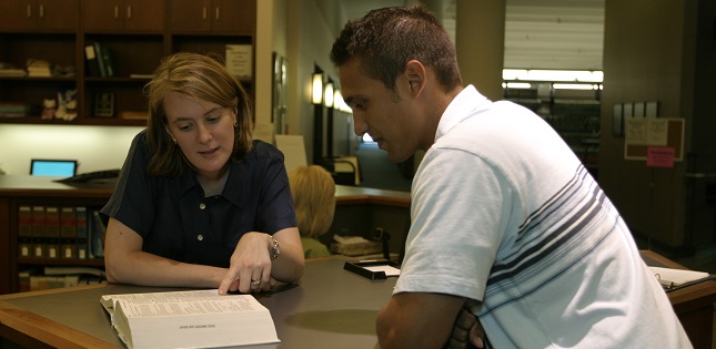 Two individuals studying in the law library