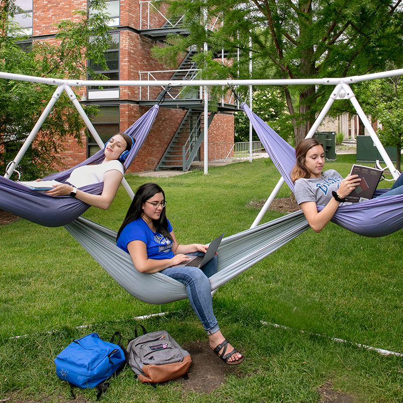 Three Drake students relax in hammocks outdoors