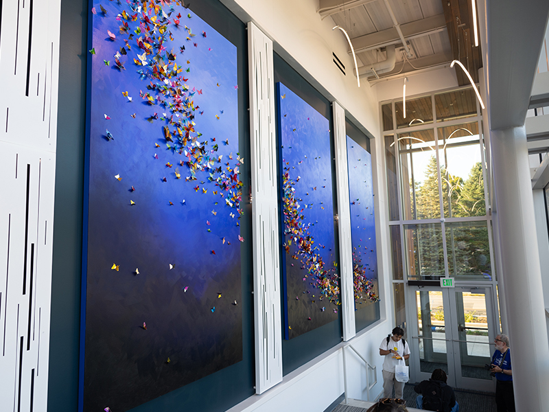 A blue wall with a detailed stream of paper cranes inside Drake University's Counseling Center