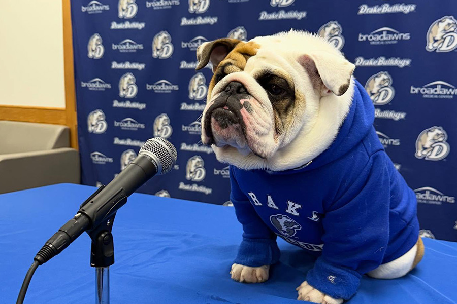Gus sitting in front of a microphone with a Drake Bulldogs and Broadlawns step and repeat background behind him