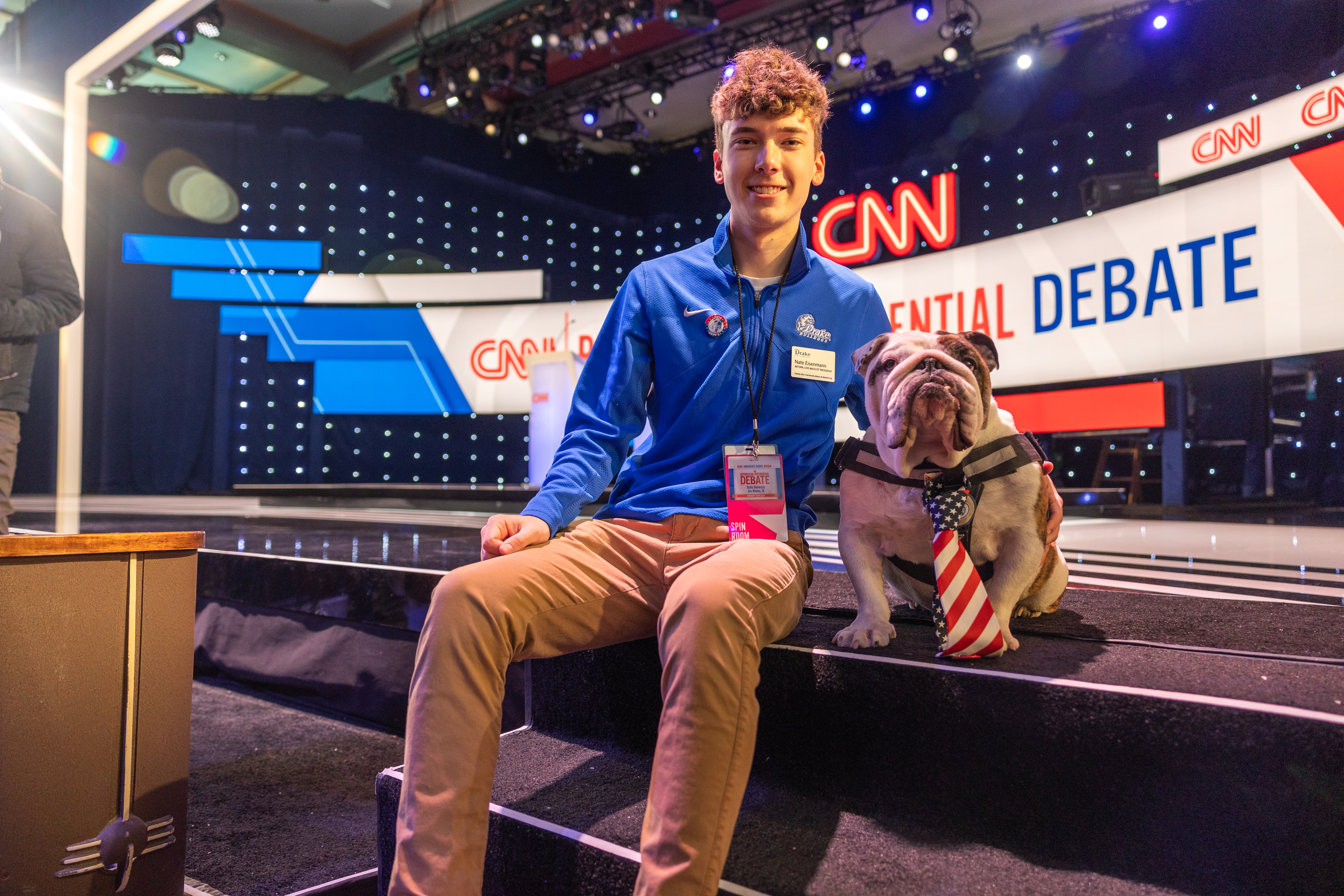 A Drake student with a press pass for the Iowa Republican Presidential Debate embraces Griff, in a Stars and Stripes tie, on CNN's set
