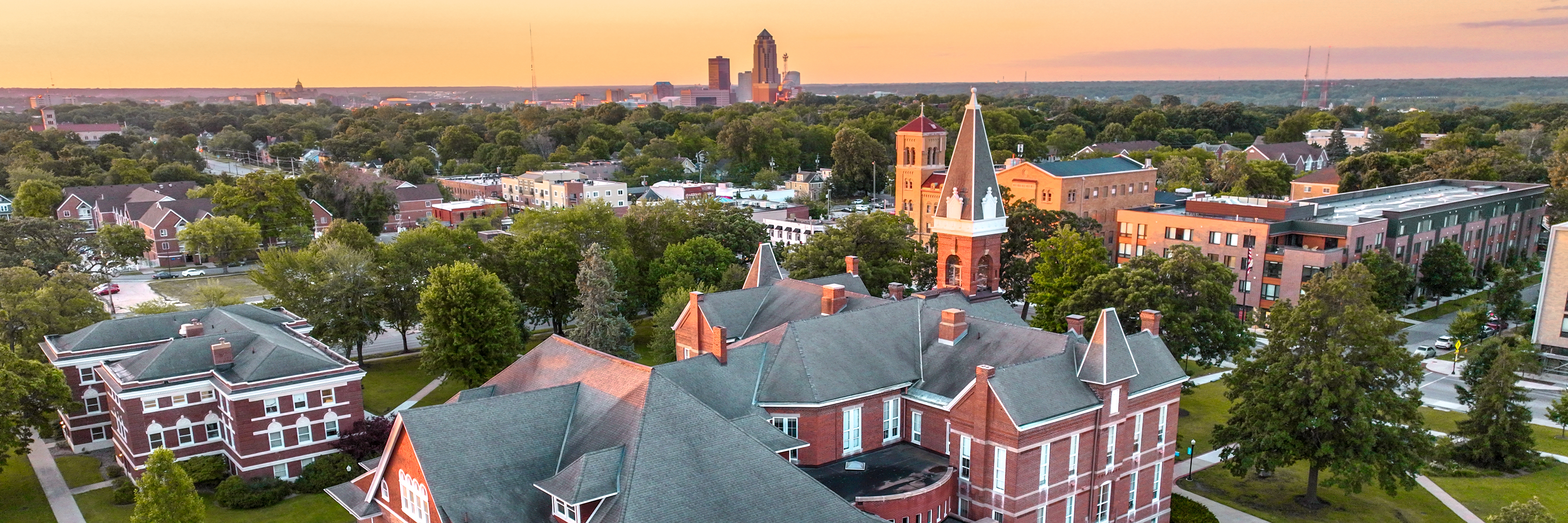 A drone view of the brick buildings on the Drake University campus as the sun sets