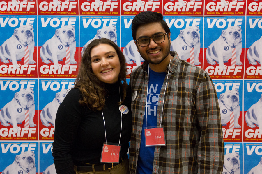 Two Drake journalism students stand in front of political-style posters of Griff during a mock caucus event held on campus