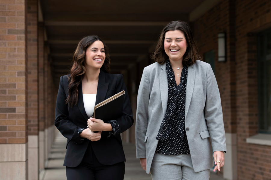 Two Drake 3+3 Law Students wearing suits walk through campus between classes