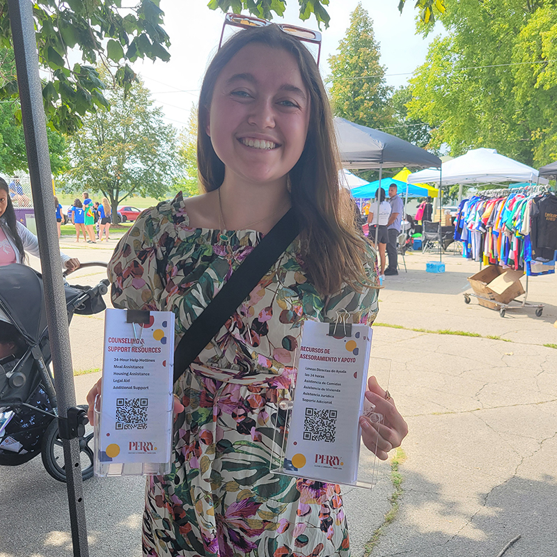 Allie Raines holding materials she designed for the PerryNext Campaign