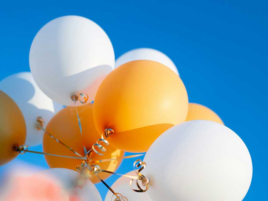 Looking up to the sky with balloons.